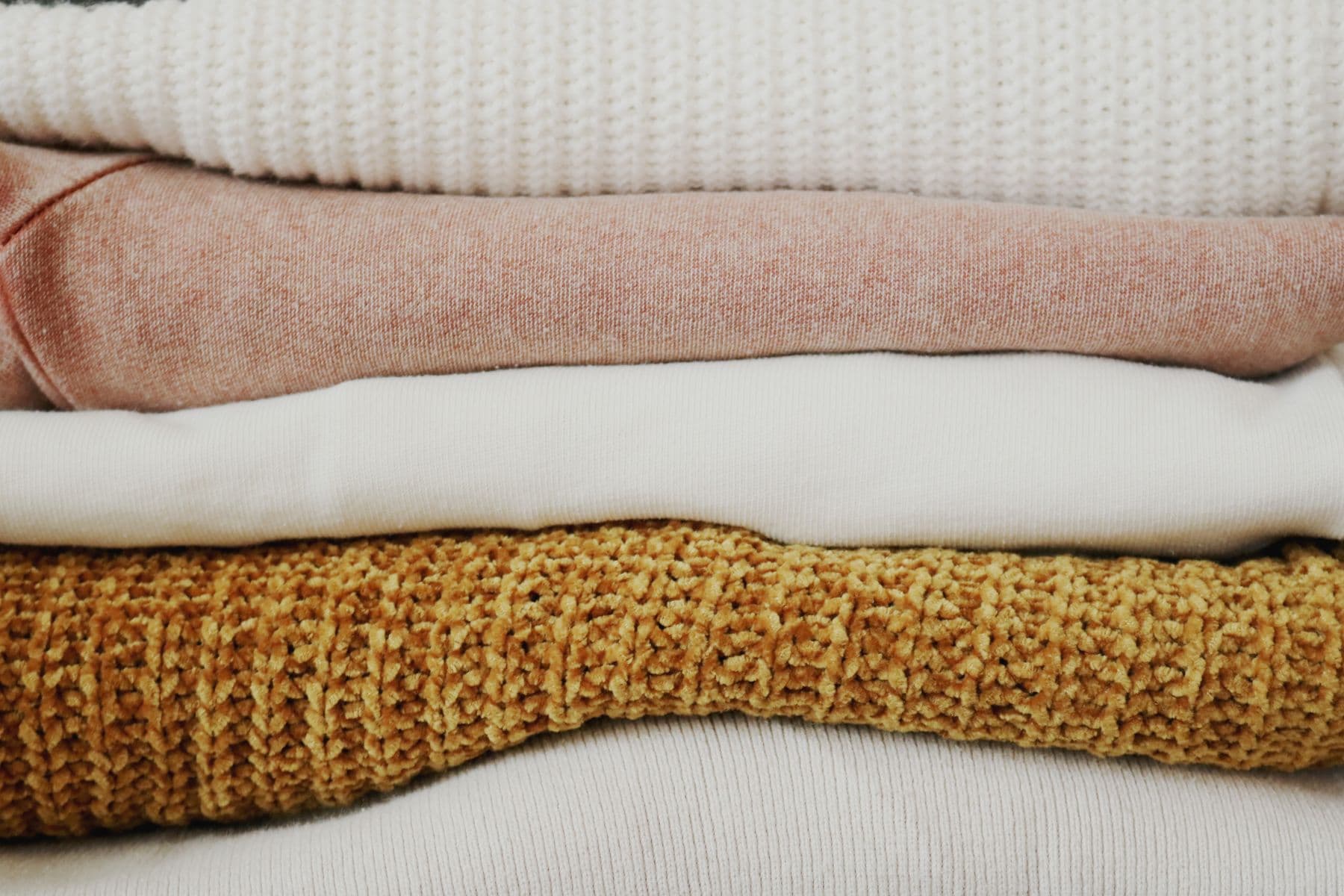 Folded knit fabrics in cream, blush and mustard