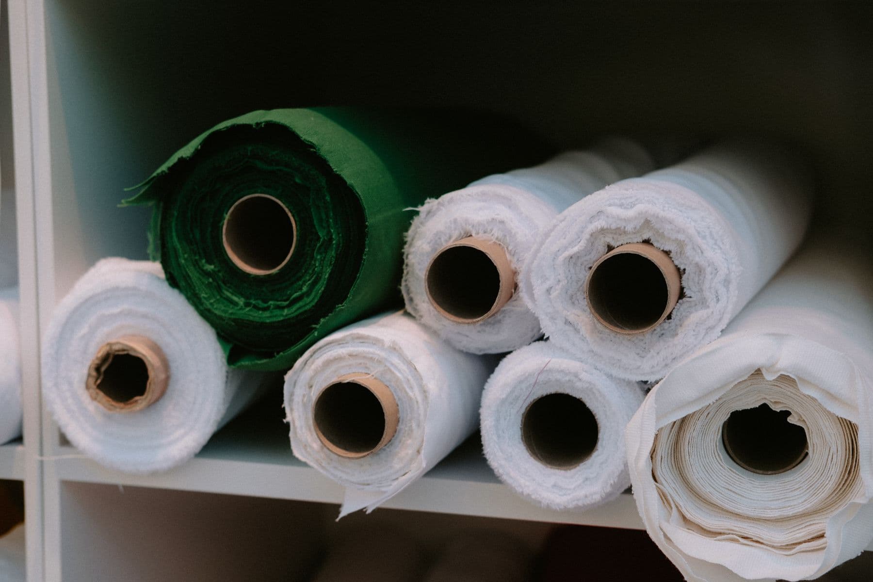 Rolls of fabric on a shelf