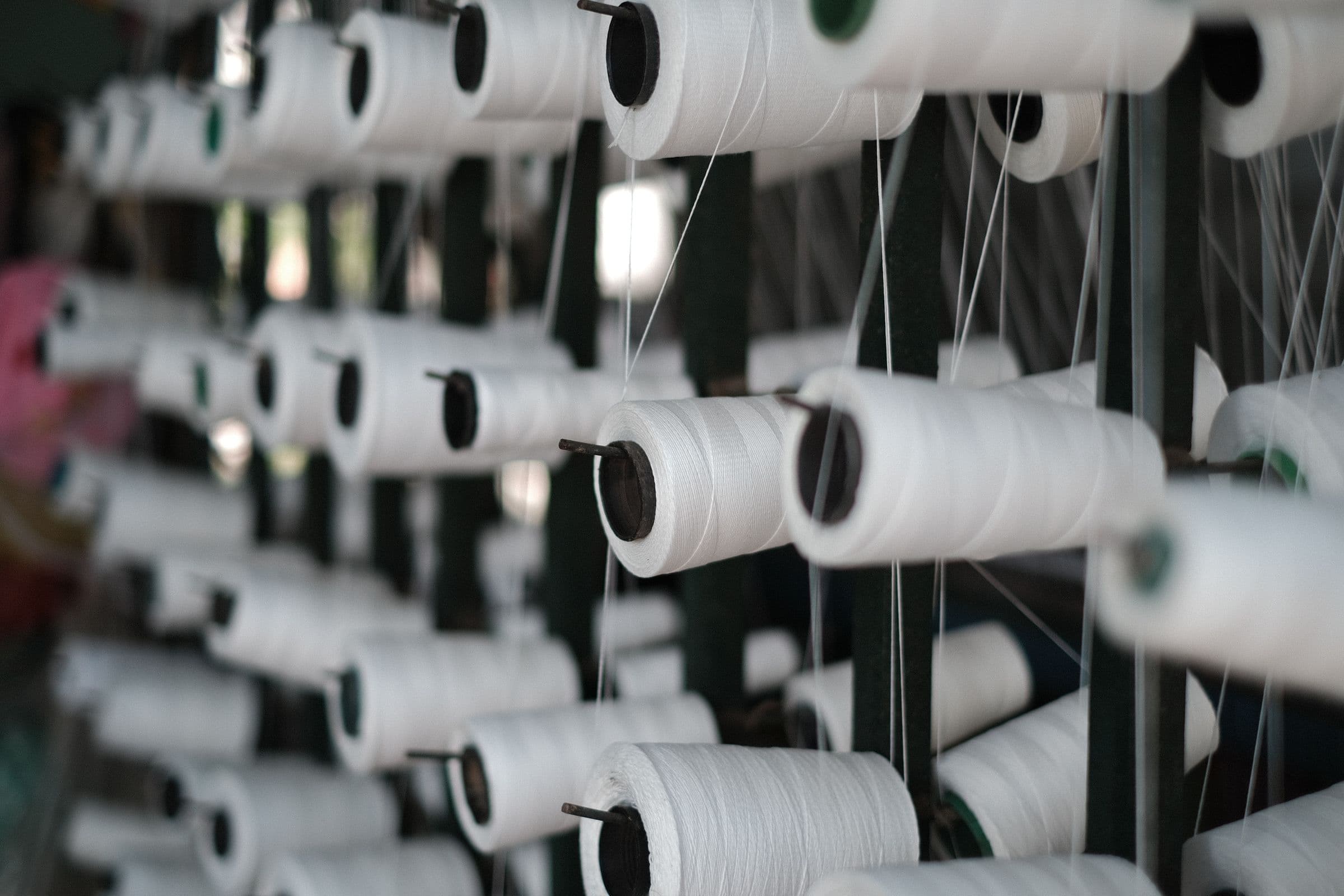 Cones of white yarn on a creel